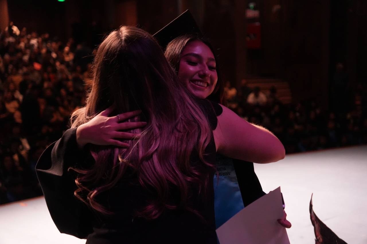 Graduadas de la Universidad José Vasconcelos celebrando con un abrazo